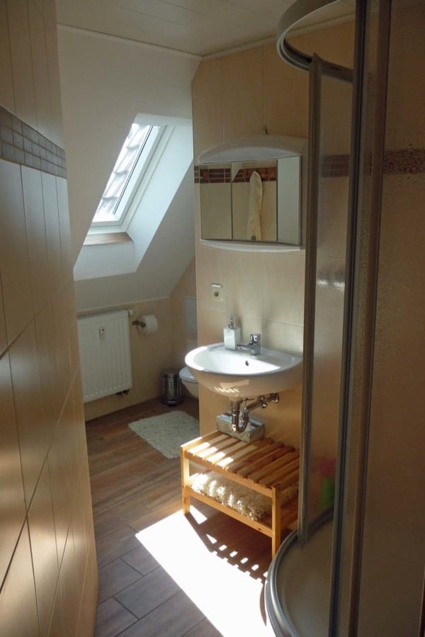Bad der Ferienwohnung mit Dusche, Waschbecken und Dachfenster