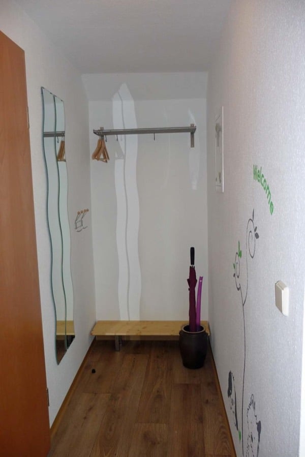 Flur der Ferienwohnung mit Garderobe, Spiegel und Sitzbank