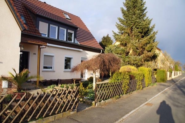 Außenansicht des Wohnhauses mit rotem Ziegeldach und Vorgarten