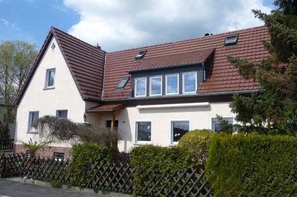 Wohnhaus mit rotem Ziegeldach, Gaube und vier Panoramafenstern