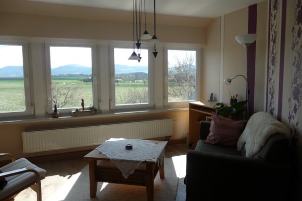 Couch und Couchtisch vor der Fensterfront der Ferienwohnung